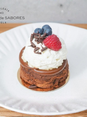 Porción de Marquise de chocolate sin gluten con dulce de leche, nata y frutos rojos