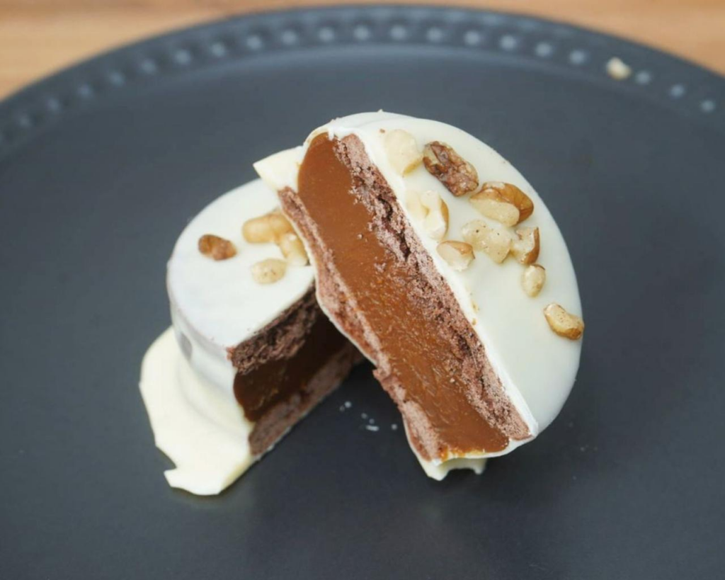 Alfajor de nuez sin gluten relleno de dulce de leche y cubierto de chocolate blanco