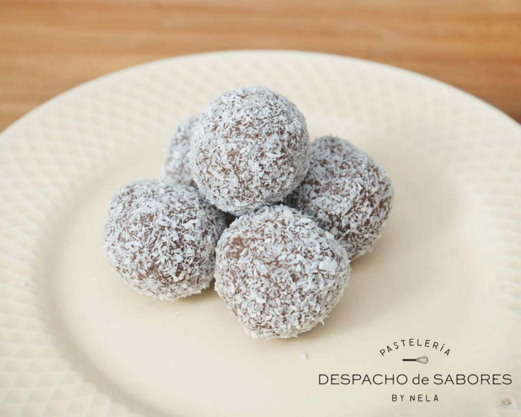 Tres trufas de chocolate y dátil sin gluten cubiertas con coco rallado